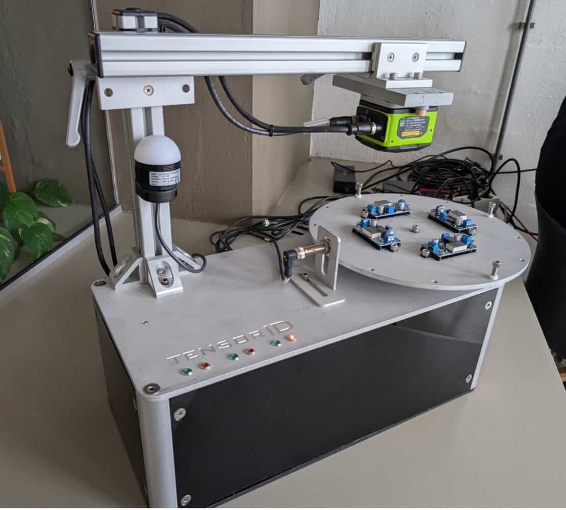 Zebra NS42 Smart Vision Sensor_1 Een robotapparaat met een roterend platform dat elektronische componenten bevat, uitgerust met camera's en sensoren, met het label 'TensorIOT'.